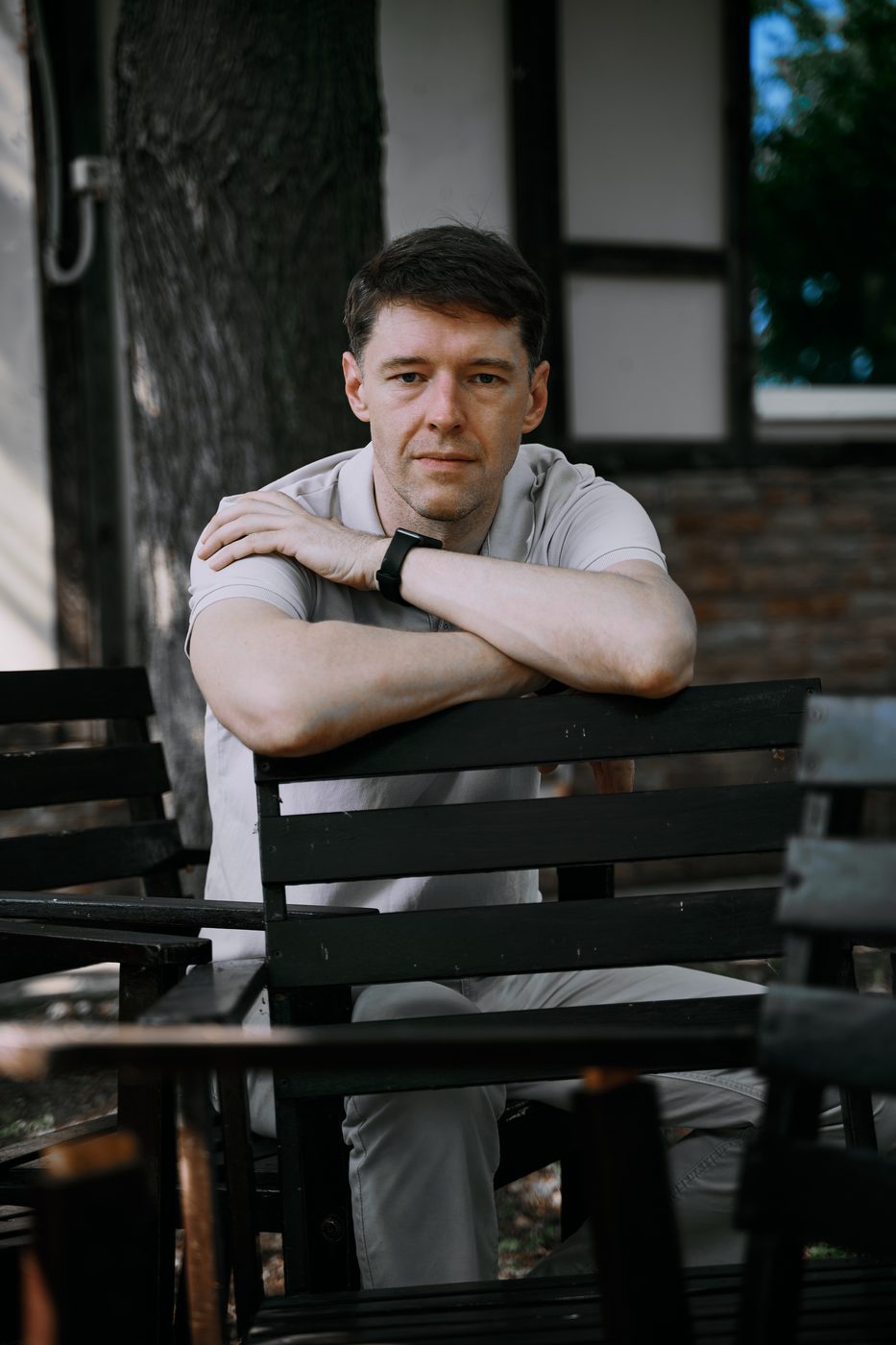 Тихон задумчиво сидит на лавке