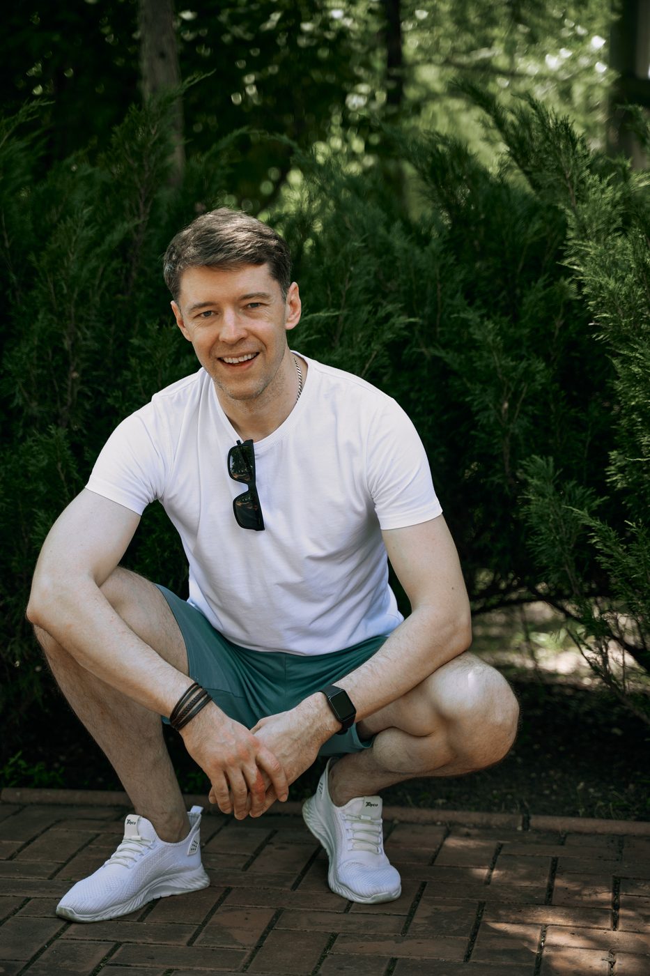 Тихон присел в саду и широко улыбается